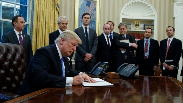 <p>Trump signs away the future surrounded by loyal underlings.</p>