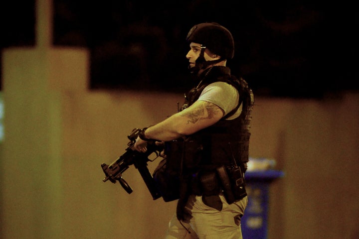 An armed police officer walks at the scene in the Melbourne bayside suburb of Brighton on June 5, 2017, after a woman was held against her will in an apartment block.