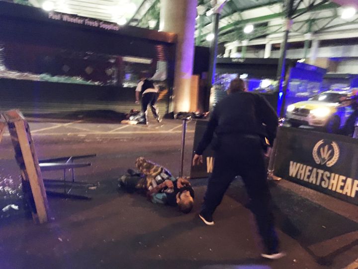 A man is seen on the ground after armed police officers opened fire in Borough Market 