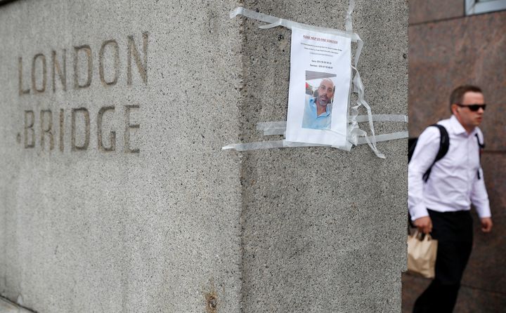 A man passes a missing poster on the south side of London Bridge 