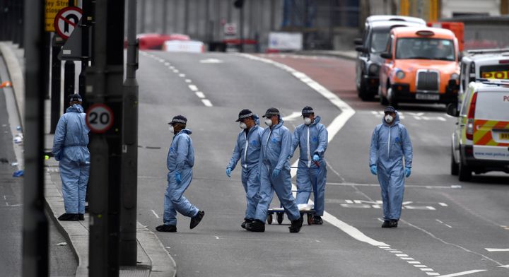 Police forensic officers work on London Bridge the day after the attack 