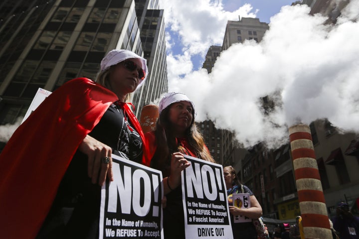 Demonstrators dressed as characters from Margaret Atwood's novel <em>The Handmaid's Tale</em> hold signs during the March For Truth protest in New York on June 3.