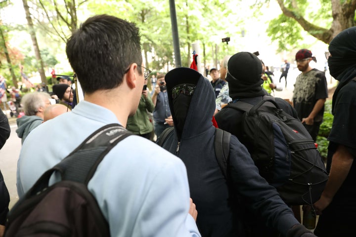 Brian Fife, a prominent far-right figure, is confronted by Black Bloc protesters on Sunday in Portland, Oregon.