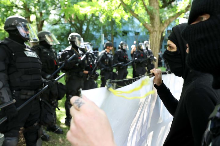 Black-clad protesters in Portland, Oregon, faced off against officers who kept them separated from pro-Trump demonstrators.