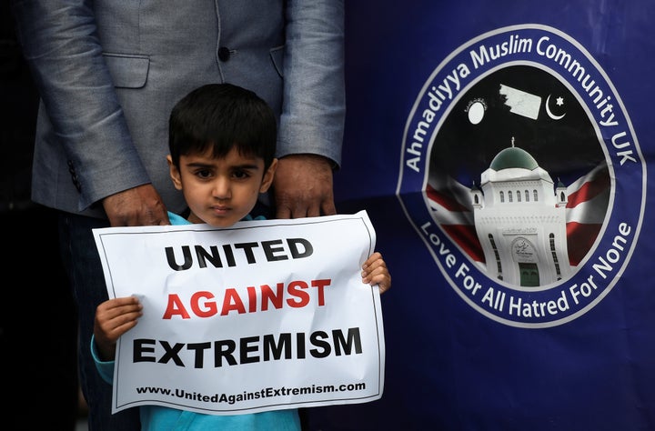 A boy holds a poster at the vigil at Potters Fields Park on Monday.