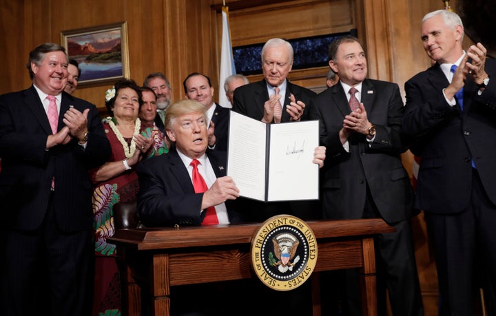 President Donald Trump holds up his executive order directing a review of previous national monument designations during a signing ceremony at the Interior Department in Washington, D.C., in April.