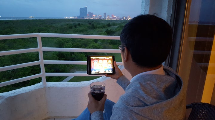 A gambler weighs his online casino gambling options from the comfort of his condo balcony just outside Atlantic City. New Jersey’s gambling revenue has improved with the advent of casino-sponsored online gambling, and other states are starting to follow suit.