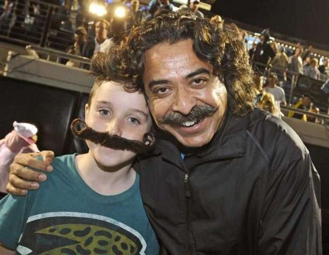 Jacksonville Jaguars owner Shahid Kahn embraces a prospective Mustached American fan