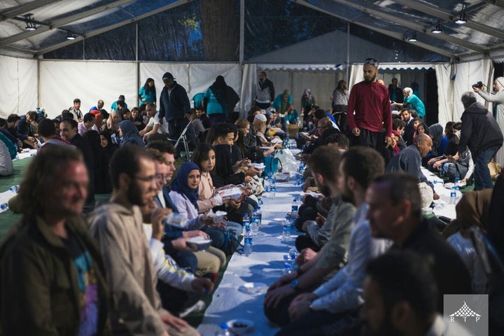 At an Open Iftar event, people of different faiths, races, and backgrounds eat a meal together.