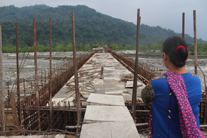 A Idu lady looks at the unfinished Dipu Nallah bridge, with Tezu on the other side.