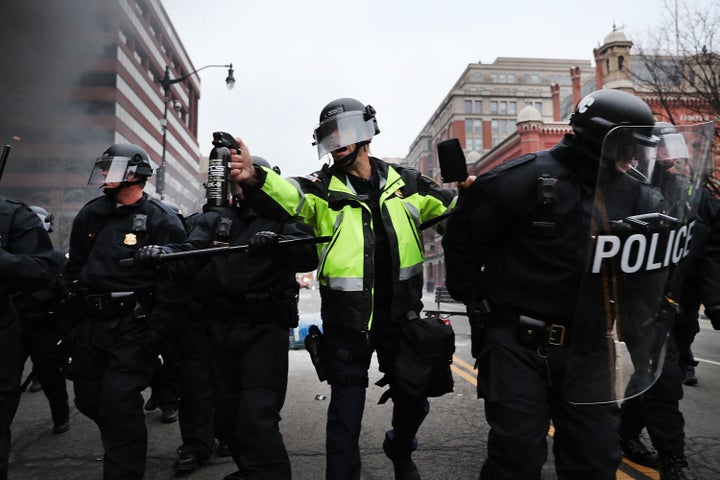 Police officers responded to inauguration protesters with tear gas after violence erupted and a limo was set on fire.