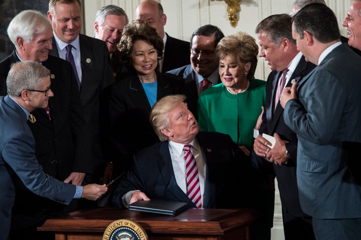 President Donald Trump at his tiny desk signs a memo to Congress outlining his plan to privatize the nation's air traffic con