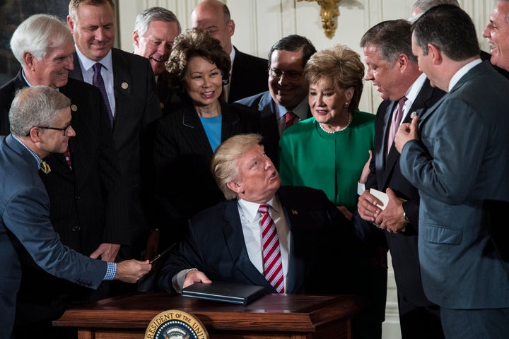 President Donald Trump at his tiny desk signs a memo to Congress outlining his plan to privatize the nation's air traffic control system at the White House on Monday.