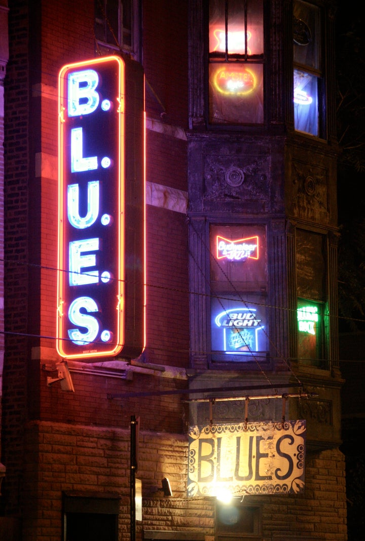 <p>The façade and neon signs at B.L.U.E.S.</p>