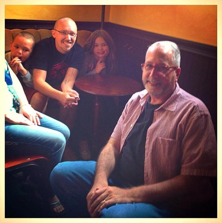 <p>Josh Misner, left, and two of his children visit with his father figure Jerry Ray</p>