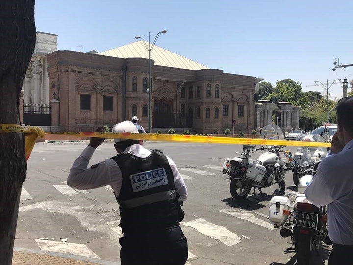 Police take security measures at the scene after gunmen opened fire at Iran's parliament and at the shrine of Ayatollah Ruhol