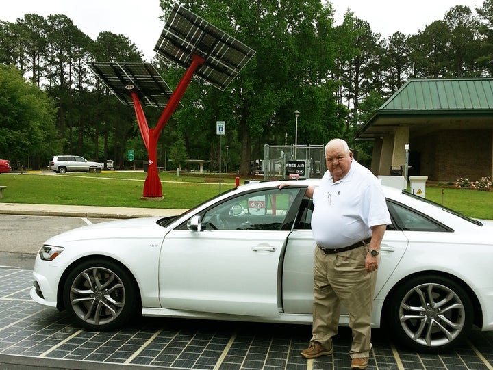 John Robinson of Mobile, Alabama, parks his car on a solar road surface in front of a “solar tree” at the West Point, Georgia
