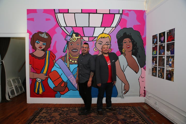 <p><em>Artists Chucha Marquez and Julio Salgado pose next to a temporary mural they designed together and painted with the help of queer friends and chosen family. The mural is a homage to Jose Sarria, Marsha P. Johnson, Brenda Lee Marquez McCool and Dorian Corey. </em></p>
