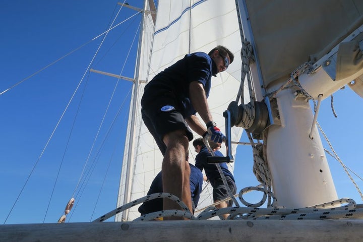 <p>The crew raising the sails</p>