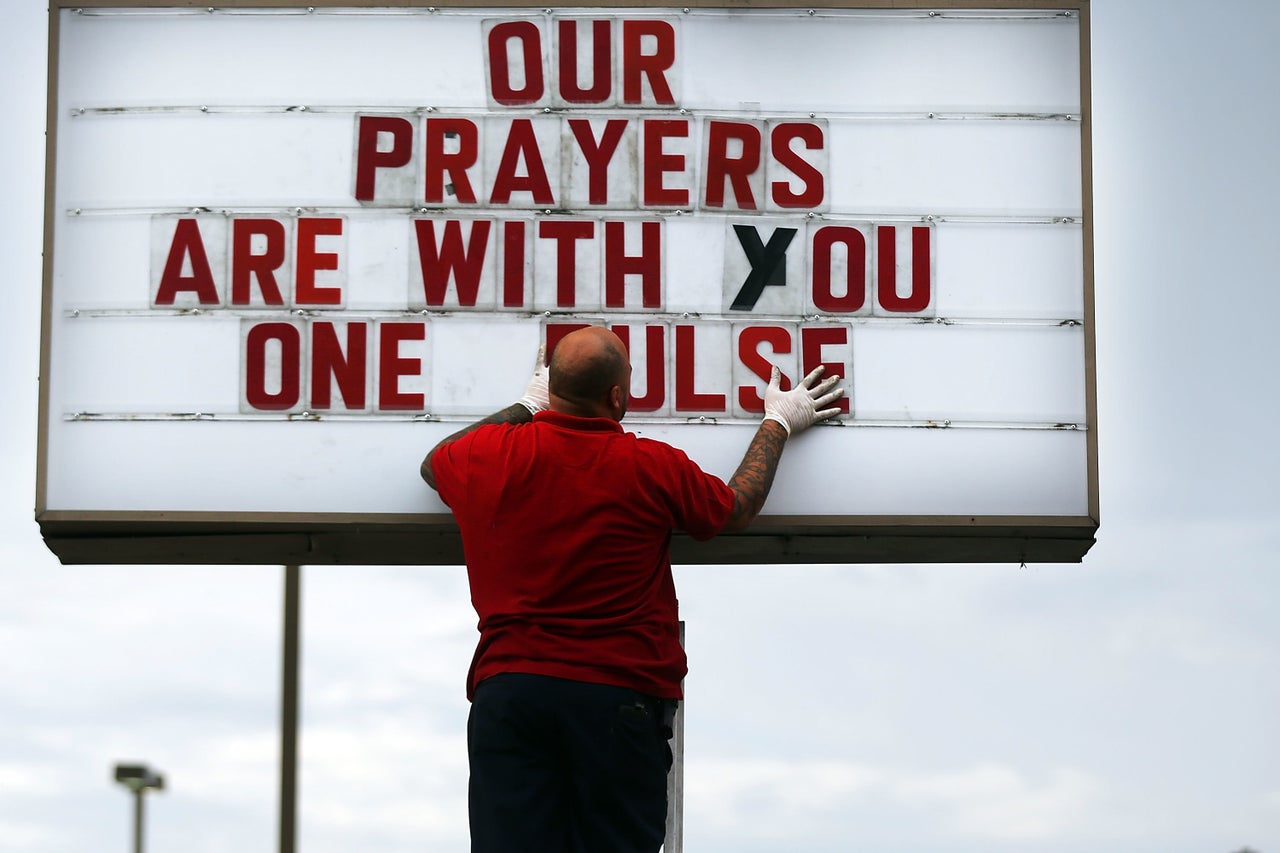 ORLANDO, FL - JUNE 16: Jiffy Lube employee Ralph Nieves put up a sign of support for the Orlando community following the shooting at the Pulse nightclub last Saturday night on June 16, 2016 in Orlando, Florida.