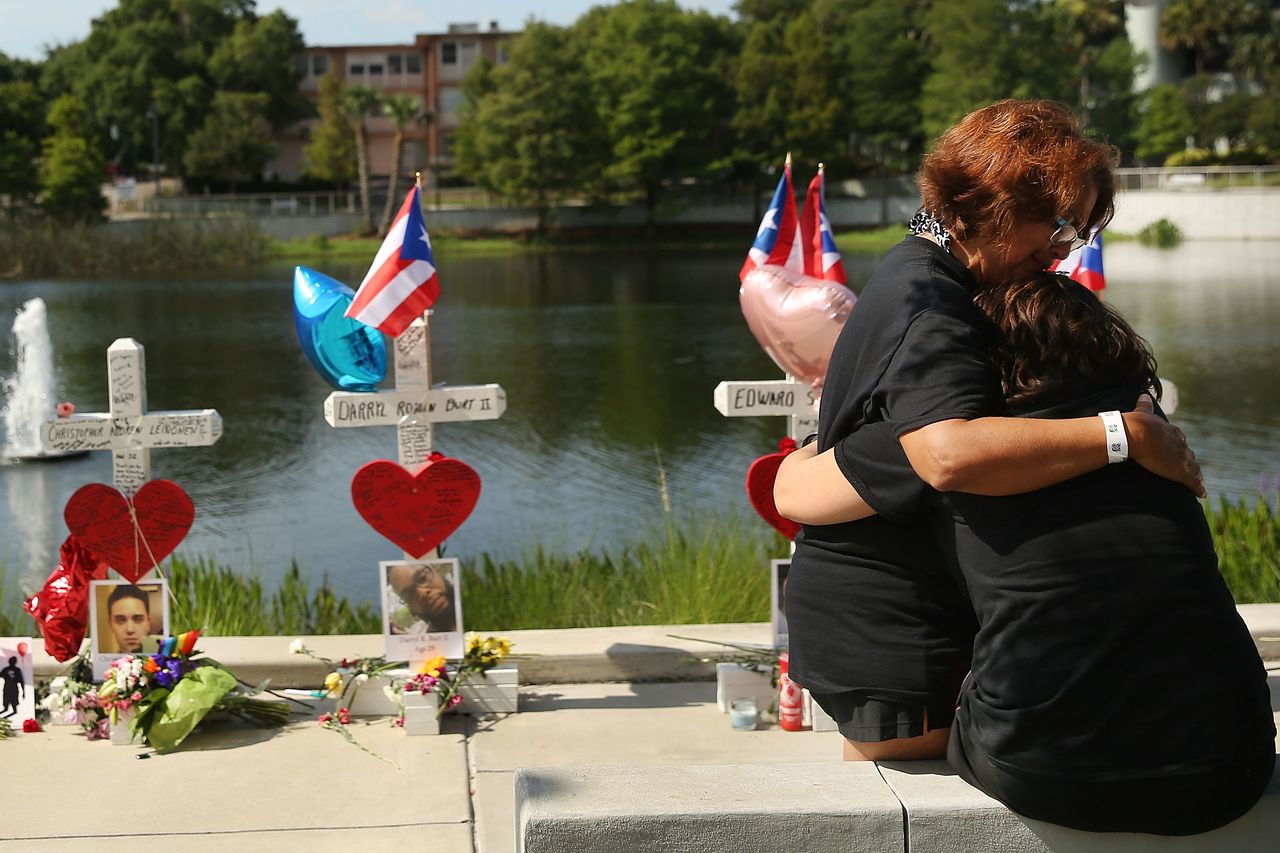 ORLANDO, FL - JUNE 18: Two women embrace beside a memorial down the road from the Pulse nightclub on June 18, 2016 in Orlando, Florida.
