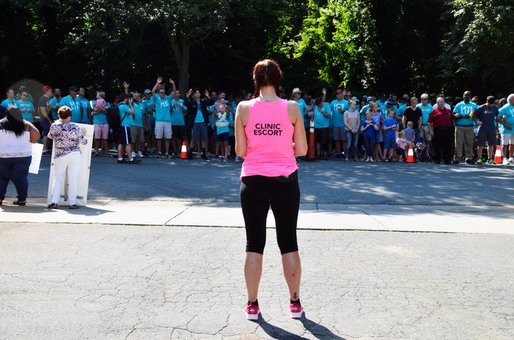 A volunteer clinic escort and member of Pro-choice Charlotte waits in the clinic parking lot to direct patients past throngs of protesters at a protest in Charlotte, North Carolina in June 2017.