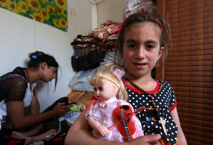 Christena, a 6-year-old Iraqi Christian girl, holds a doll during a meeting with her family at a camp for displaced Christian