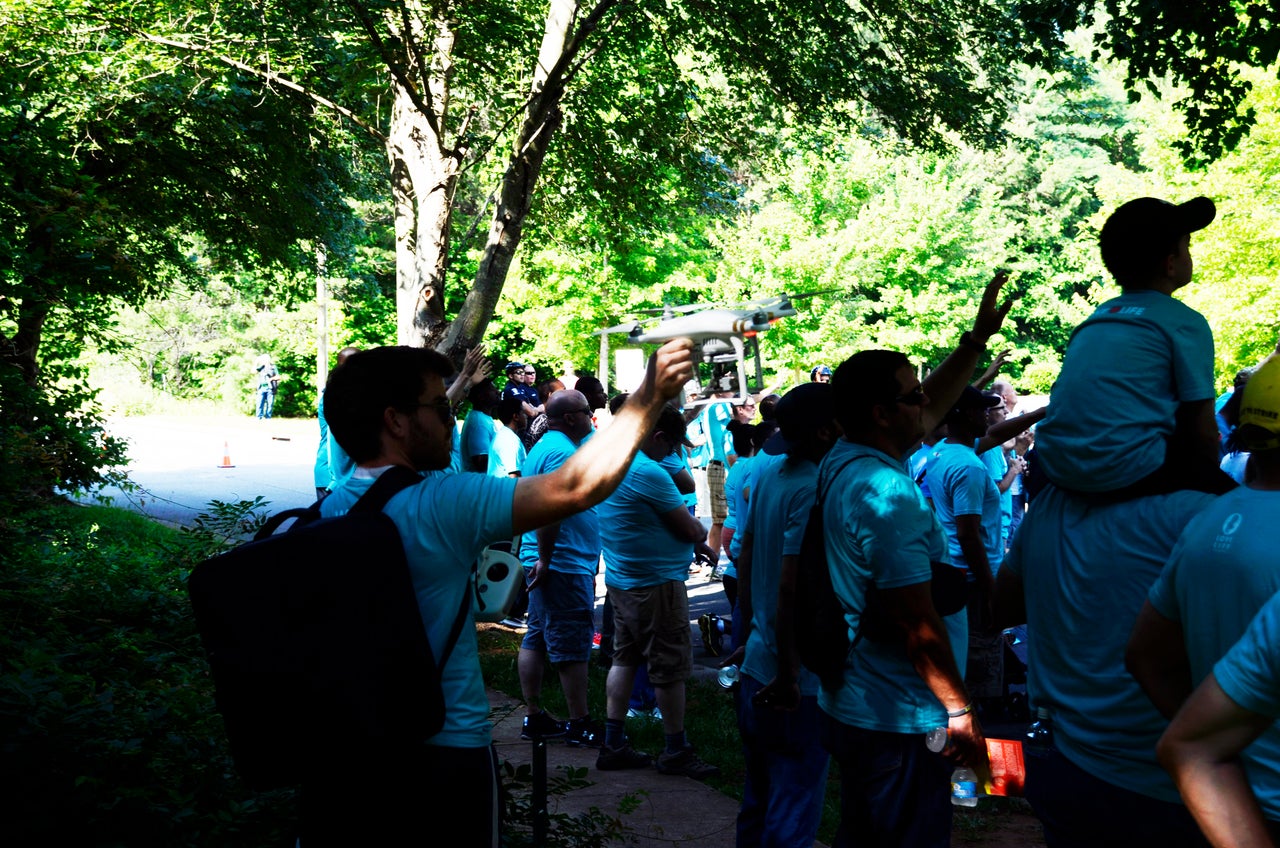 A young member of LLC points a drone to in the direction of the clinic. The use of drones outside private property without written consent from the property owner is illegal in North Carolina.