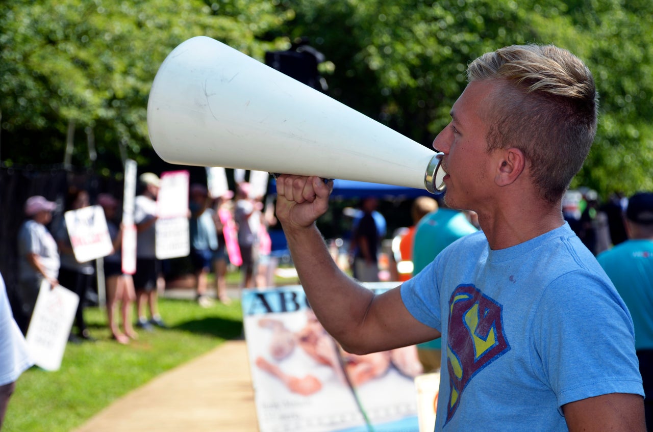 One anti-abortion protester uses a megaphone to yell outside the clinic. "You're a coward," he said, to the male partner of a patient.