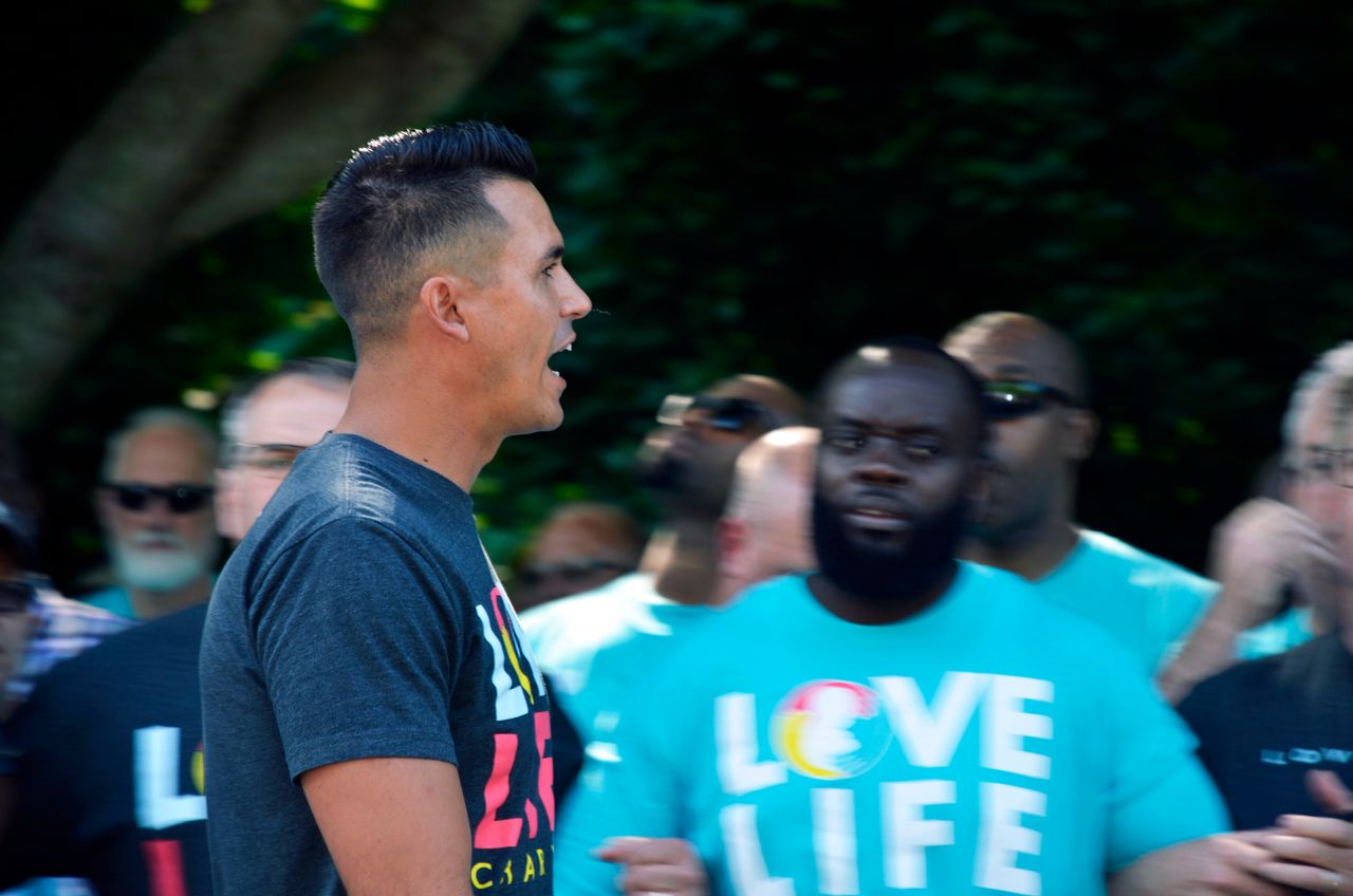Love Live Charlotte founder Justin Reeder pumps up hundreds of men as they rally outside the clinic. 