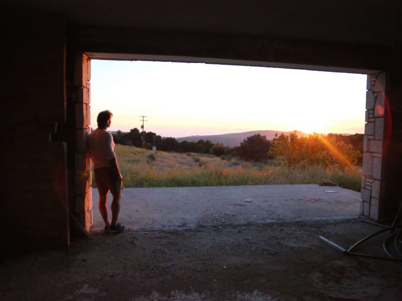 Kostas Bozikis looks out over his land towards the proposed dumping site, from inside the house he is building