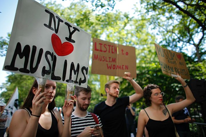 People hold up signs during a rally to support muslims rights as a counter-protest to an anti-sharia law rally origanized by ACT for America on June 10, 2017 at City Hall in New York. ACT for America has become an increasingly vocal anti-Muslim activist group, and has organized protests across the United States.