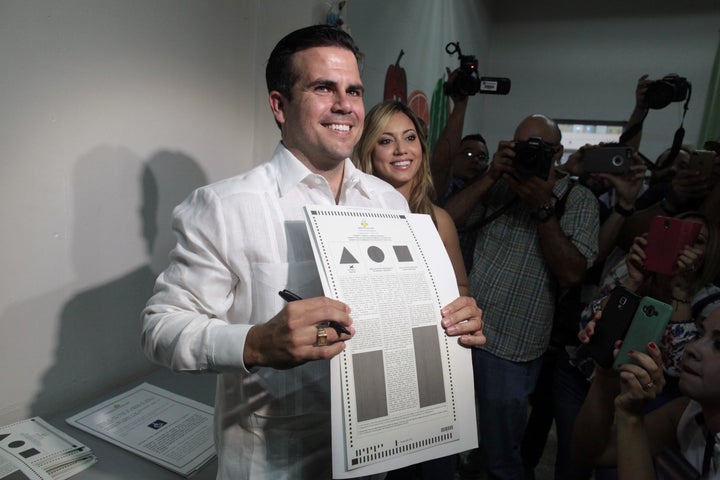 Puerto Rico Governor Ricardo Rossello (C) shows his ballot paper next to his wife Beatriz Rossello as Puerto Ricans head to the polls on Sunday to decide whether they want their struggling U.S. territory to become the 51st U.S. state, in Guaynabo, Puerto Rico, June 11, 2017. (REUTERS / Alvin Baez)