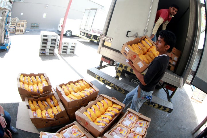 A man unloads chicken products at Al Meera market in Doha, Qatar, on Friday after people rushed grocery stores in fear of a food shortage. 