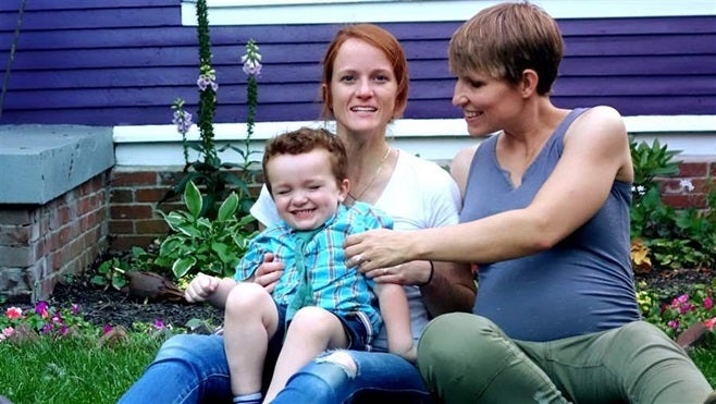 Jennifer and Nicole Singley sit with their son, Huck. The couple is one of several suing the state of Indiana to allow both members of married gay couples to be listed on a child’s birth certificate. Nicole, who serves in the military, is not biologically related to her son and worries he would not receive her military benefits.