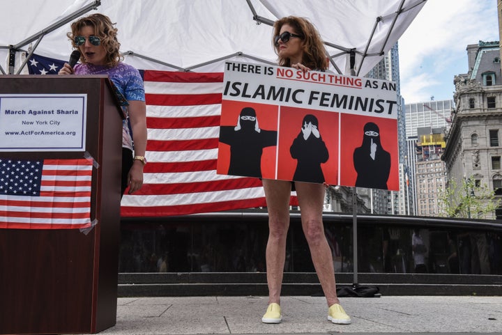 People speak and hold signs on a stage during an event called "March Against Sharia" in New York City, U.S. June 10, 2017.