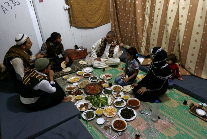 Abu Rustom, founder of a Syrian refugee folklore troupe eats Iftar with his family and troupe members, during the Muslim fast