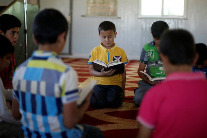 Syrian refugee boys read the Koran inside the Quran Memorization Center at the Al-Zaatari refugee camp in Mafraq, Jordan, nea