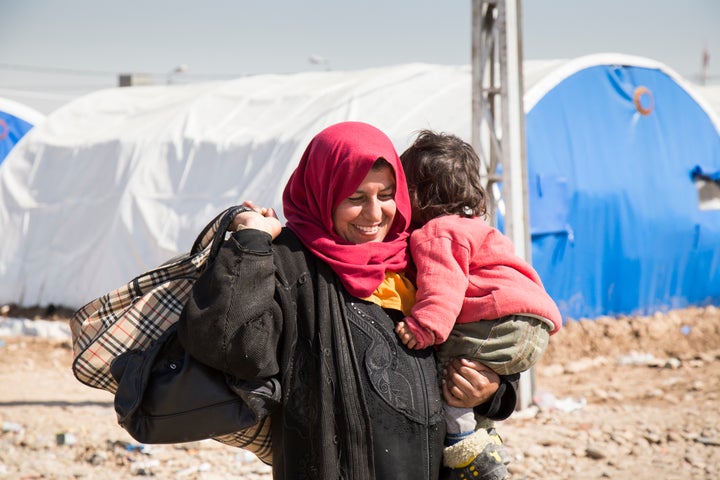 A woman walks with her daughter in Hammam al-Alil, a site roughly 25 kilometers south of Mosul, where people displaced from the western part of the city are taken to undergo security screening before being relocated to nearby emergency sites.