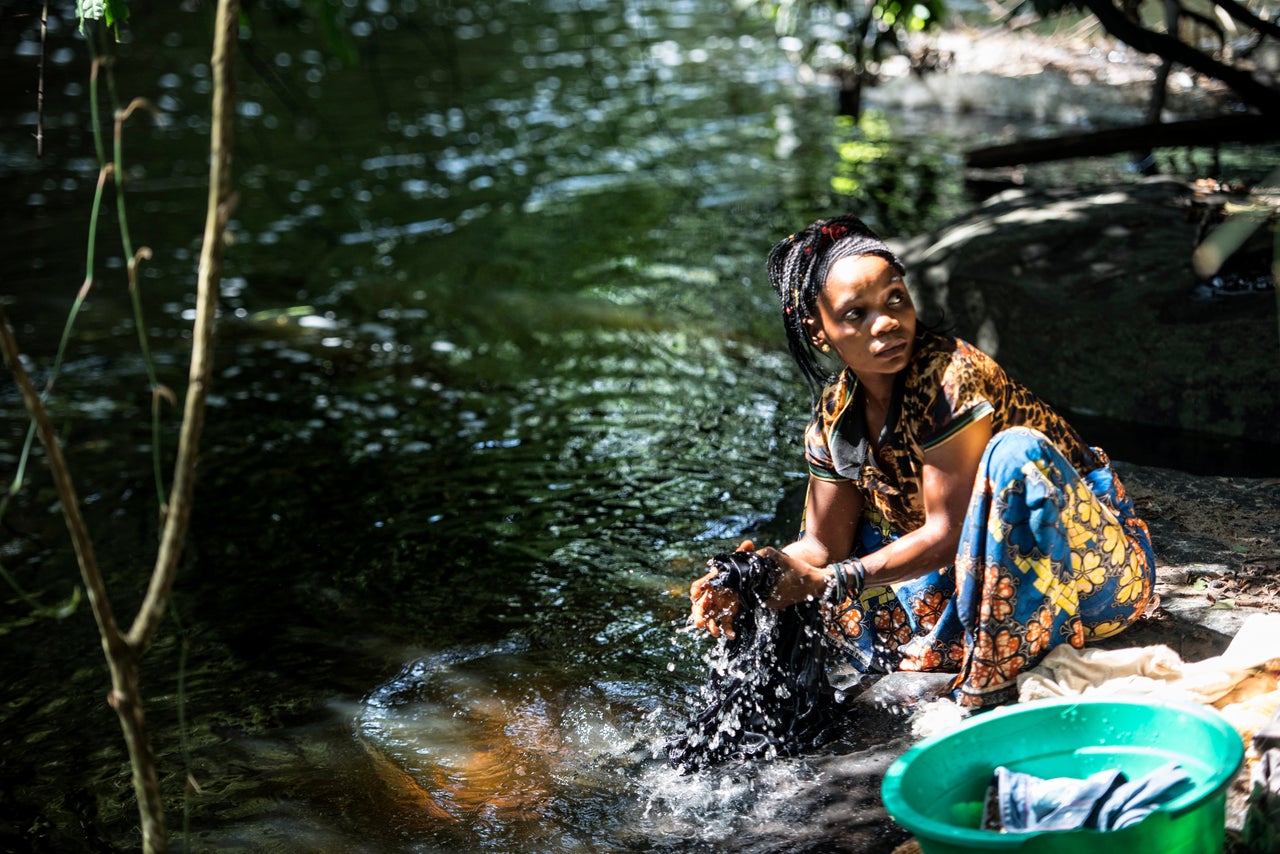 A woman washes clothes near Salambongo.