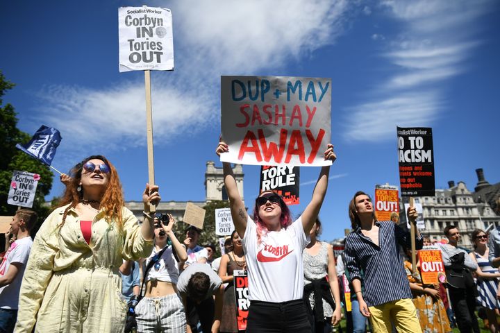 Anti-Conservative Party and anti-Democratic Unionist Party (DUP) demonstrators gather with placards in Parliament Square