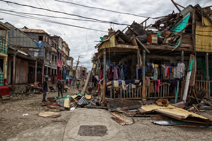 Local residents clean up streets in western Haiti in the wake of Hurricane Matthew which caused widespread damage in the Cari