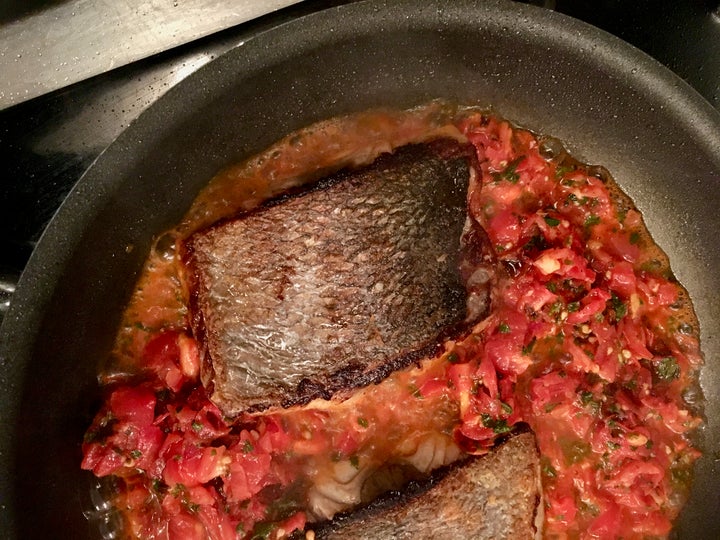 <p>The tomatoes and mint are added to the skillet; the fish finishes cooking in this mixture</p>