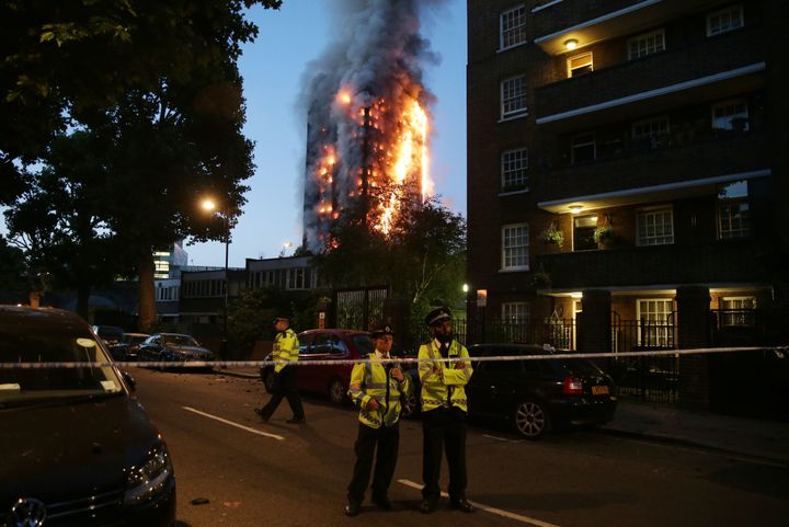 Police man a security cordon as a huge fire engulfs the Grenfell Tower in west London