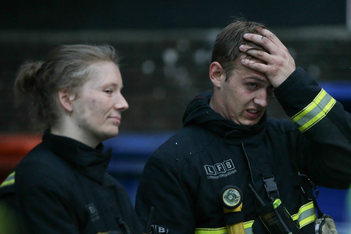 Firefighters react as they attend the scene.