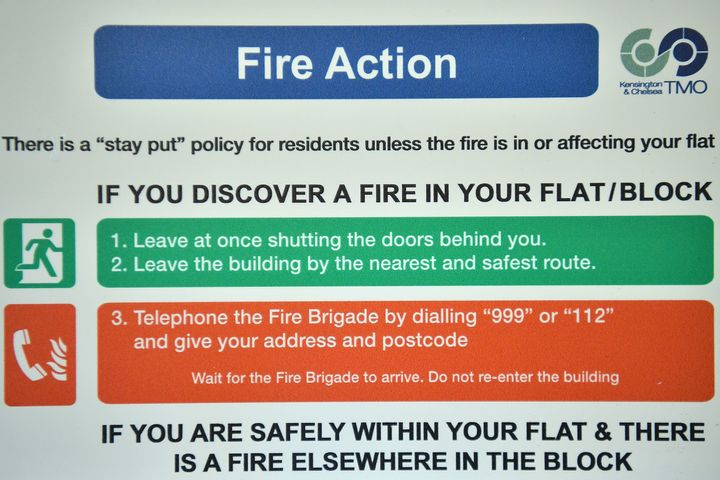 A fire safety action sign displayed inside a block near Grenfell Tower