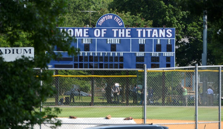 Investigators search under a scoreboard at the scene where shots were fired during a congressional baseball practice in Alexandria, Virginia; June 14, 2017.