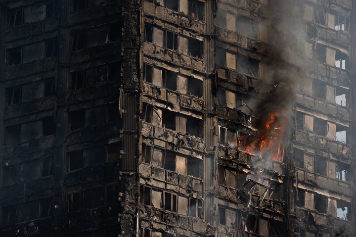 Debris falls from the burning 24 storey residential Grenfell Tower block in Latimer Road, West London on June 14, 2017 in London, England.