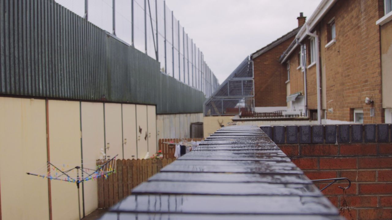 The 10ft Peace Line and protected gardens of houses in a Catholic area of the city