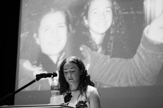 <p>A photo of Cook with her cousin, Jessica, projects on the screen behind her.</p>